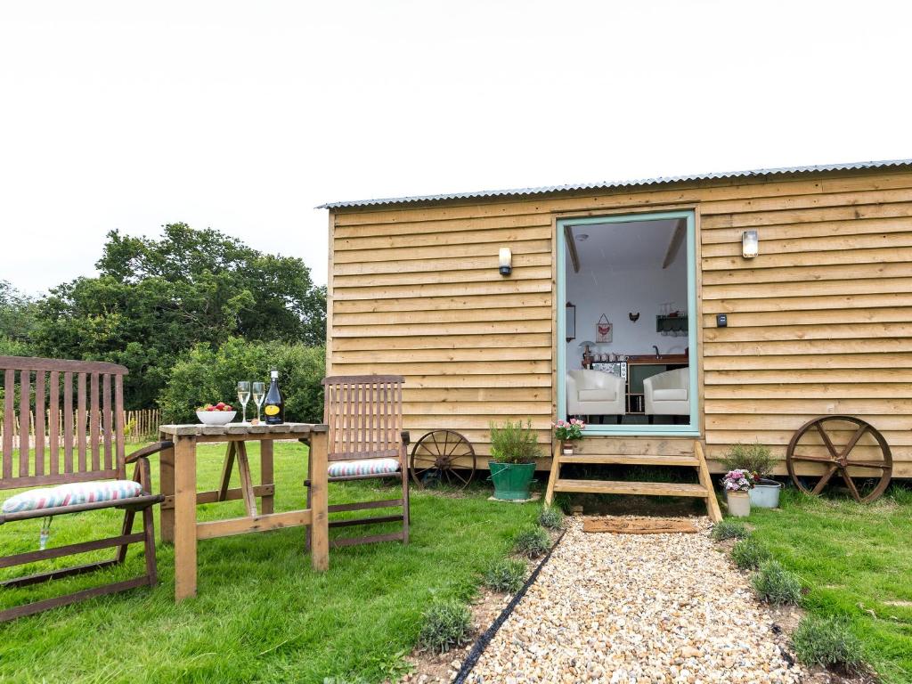 een huis met een tafel en banken ervoor bij Rosemary in Wootton Bridge