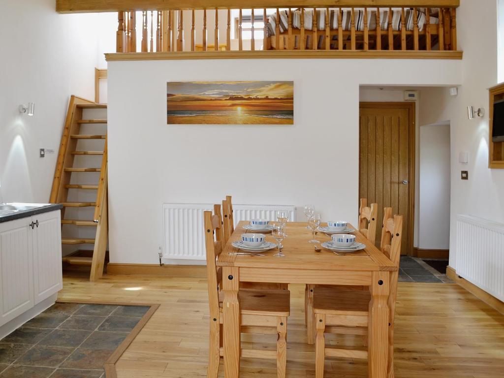Coedana的住宿－Owl Cottage，一间带木桌和椅子的用餐室