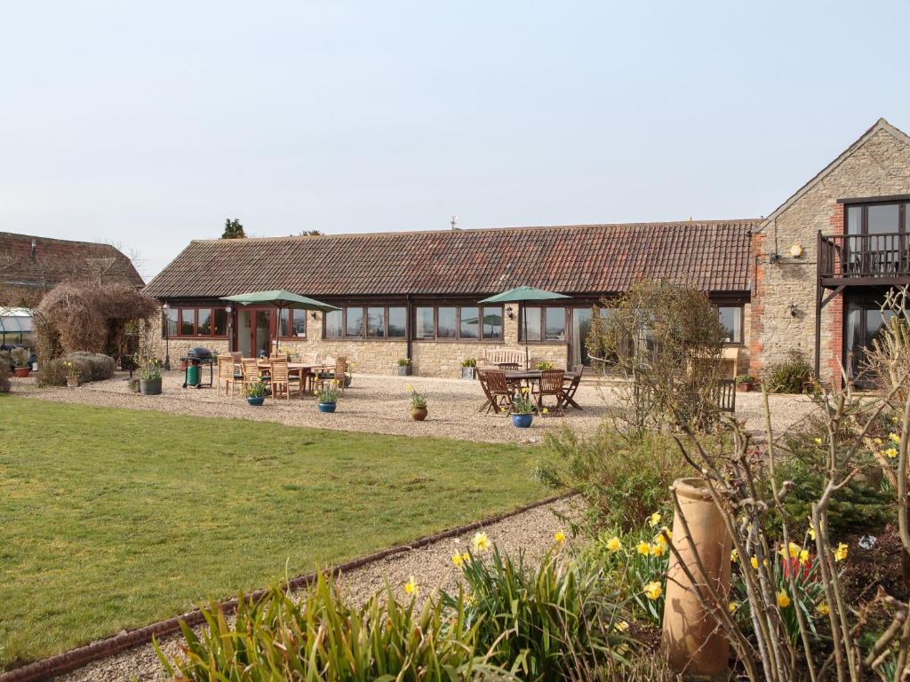 a garden with tables and benches in front of a building at Longview in Stanton Saint Quintin