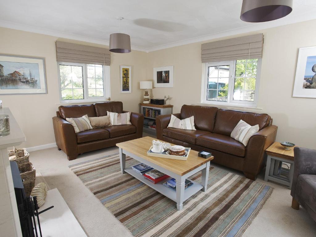 a living room with couches and a coffee table at The Retreat Lulworth in West Lulworth