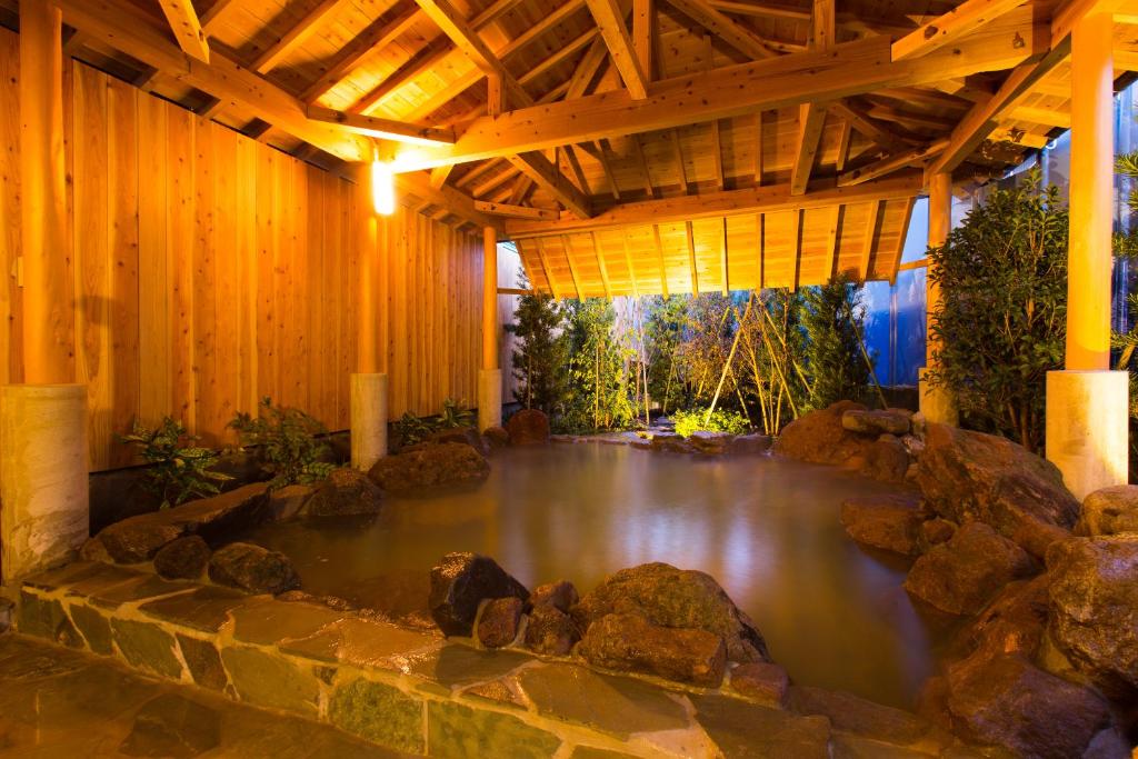 a pool of water in a building with a wooden ceiling at Hotel Seawave Beppu in Beppu