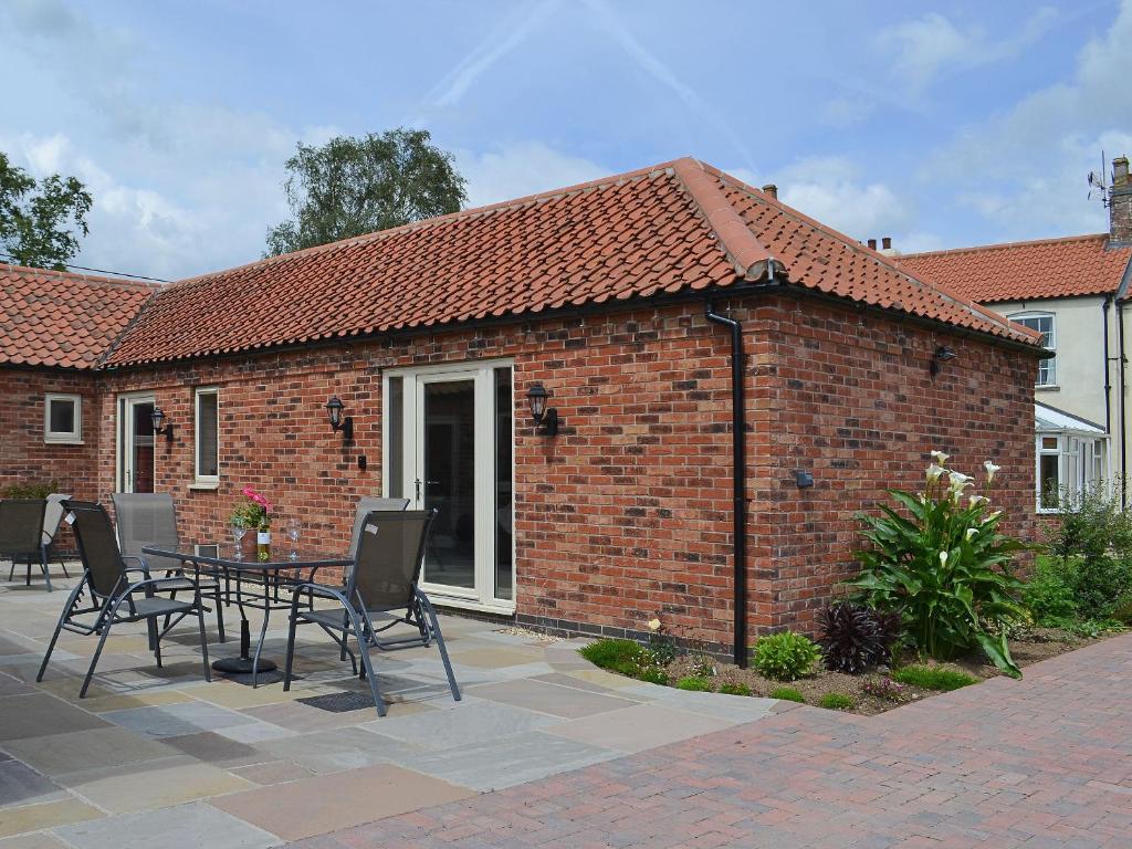 Normanton on Trent的住宿－The Parlour，一座砖砌建筑,在庭院里配有桌椅