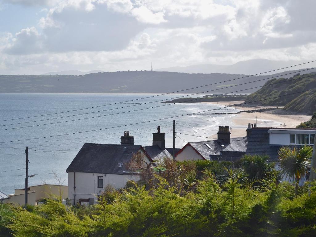 a group of houses next to a beach with the ocean at Sailfish in Benllech