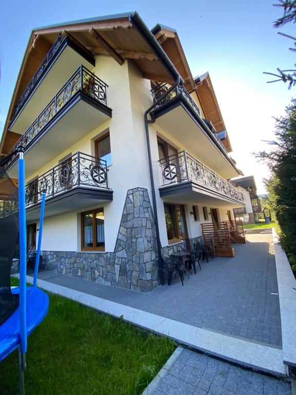 una casa con un parque infantil delante de ella en Willa Dunajcówka, en Szczawnica