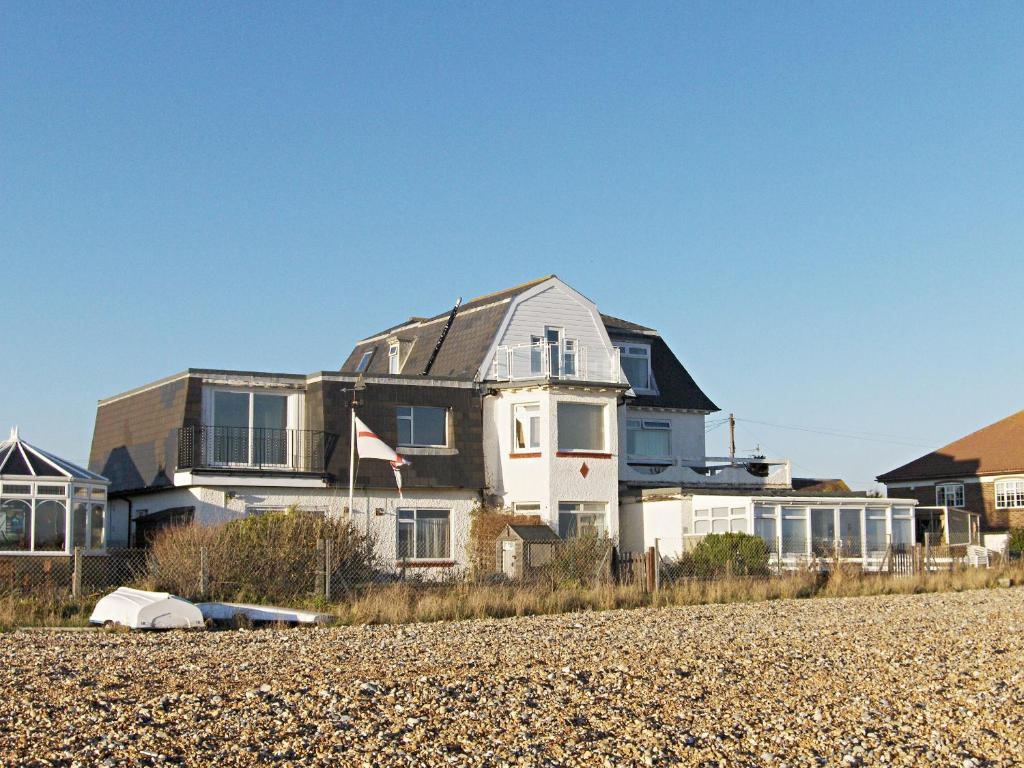 a house sitting on top of a sandy beach at 5 Coast Lodge in Pevensey