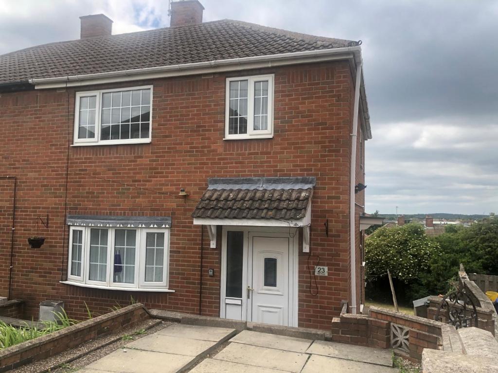 a red brick house with a white door at High rd hideaway in Warmsworth