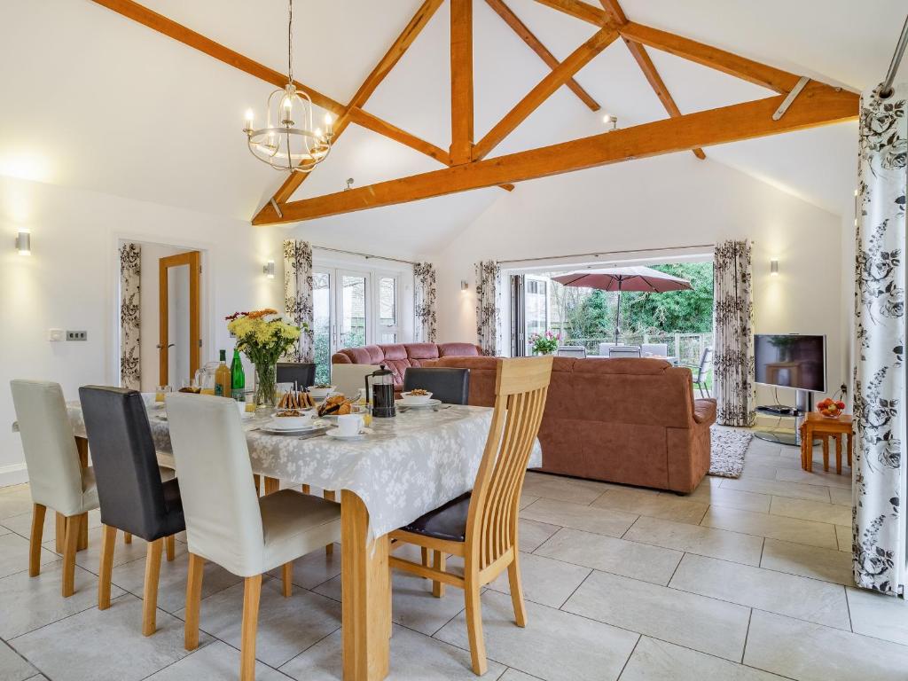 a dining room and living room with a table and chairs at Barrow Barn in Wicken