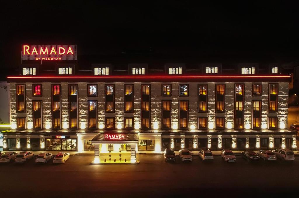 a large building with cars parked in front of it at Ramada by Wyndham Erzurum in Erzurum