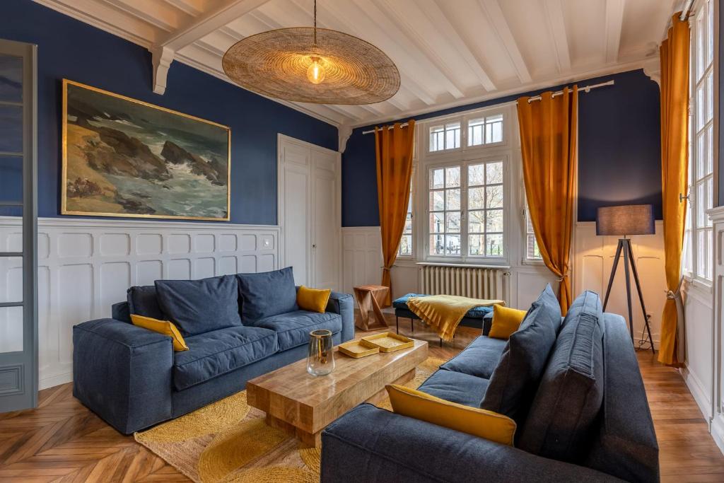 een woonkamer met blauwe banken en een tafel bij Le Manoir des EMBRUNS 14P - Location N1- Terrace- public parking 2 min in Honfleur
