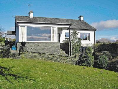 a house with a window on top of a green field at Drumlin in Hawkshead