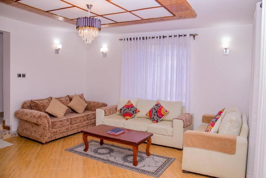 a living room with two couches and a coffee table at Hope Homestay in Syokimau