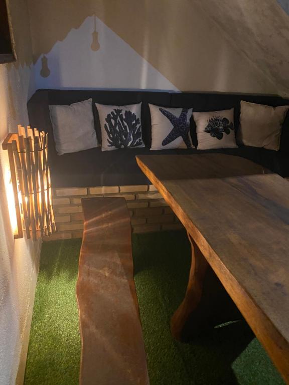 Habitación con mesa de madera y sofá en Cabana dos Milagres aconchegante a 150m da praia e WI FI en São Miguel dos Milagres