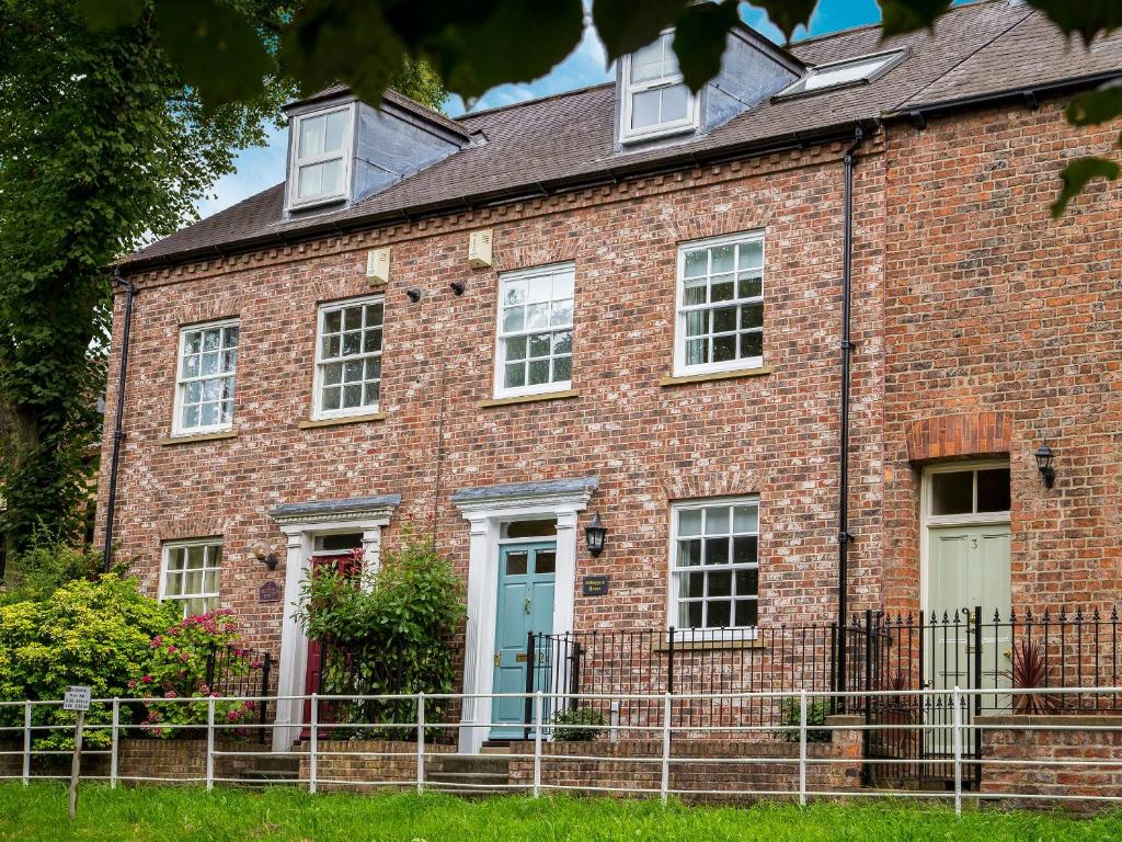 a brick house with a blue door and windows at Abbeygate House in York