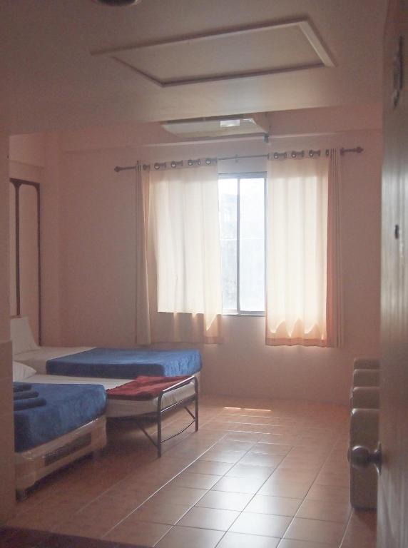 Habitación con 2 camas y 2 ventanas. en Indra Hotel Hatyai en Hat Yai