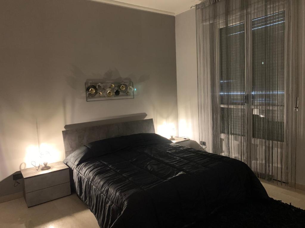 una camera con un letto, due lampade e una finestra di “L’ Angolo dei Sogni” Apartment a Casale Monferrato