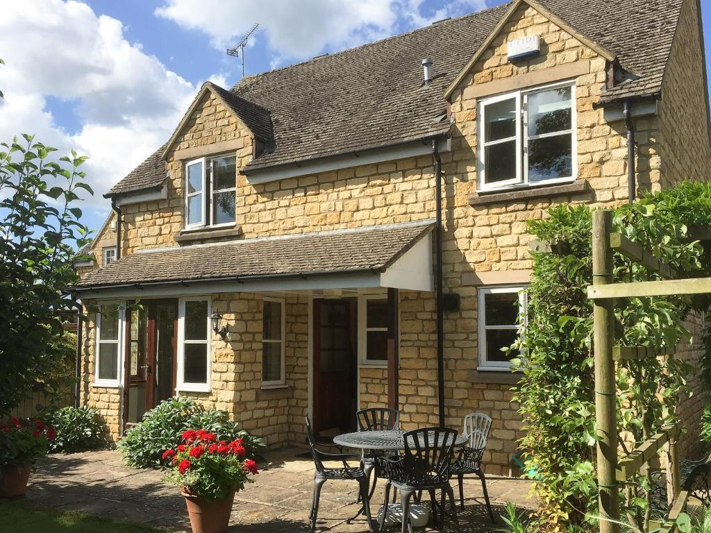 a house with a table and chairs in front of it at Russet Cottage in Moreton in Marsh