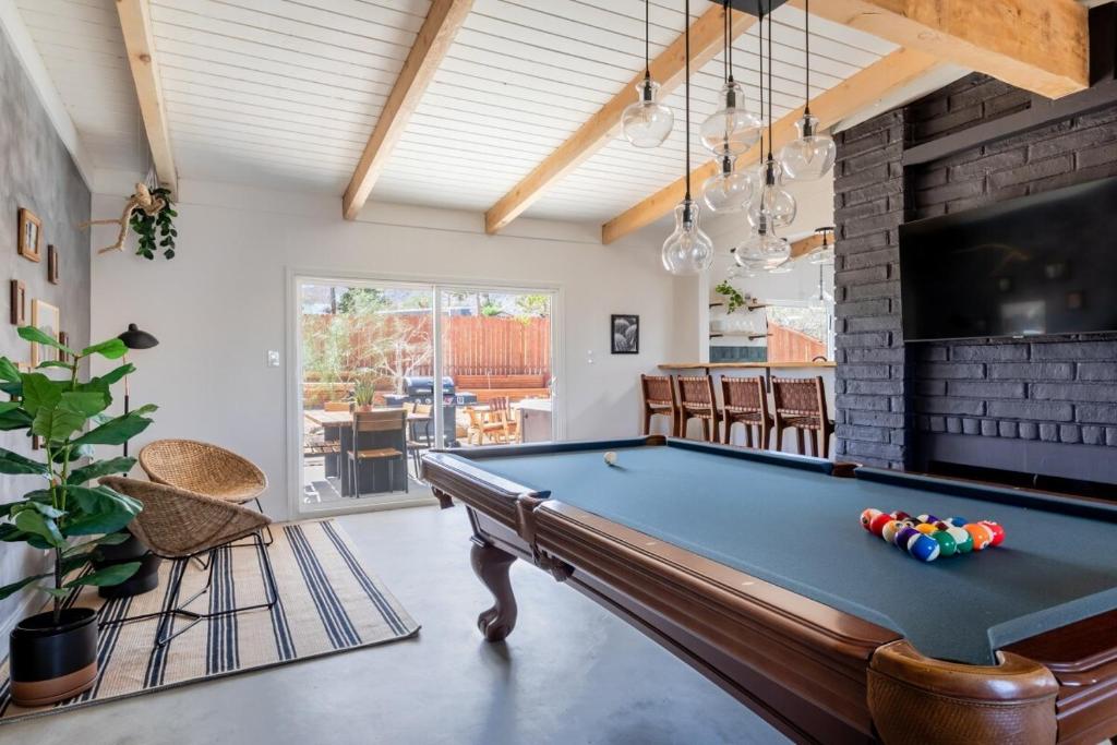 a pool table in a living room with a ceiling at 2 Min To Dt, Fire Pit, Hot Tub, Fully Fenced in Joshua Tree