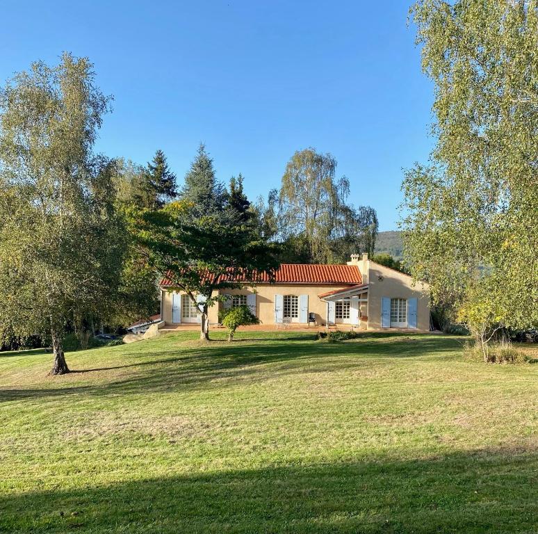 una casa en un campo de hierba con un árbol en Foix Villa 150m2 dans très grand parc arboré en Foix