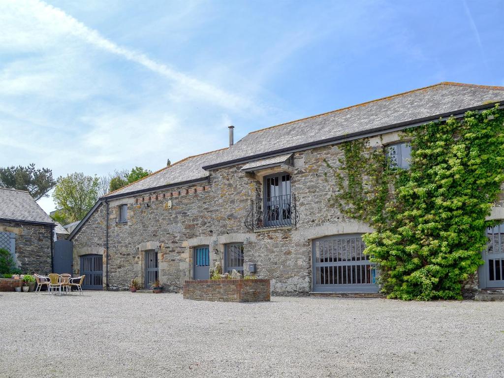 a large stone building with a tree at Trescowthick Barn in Zelah