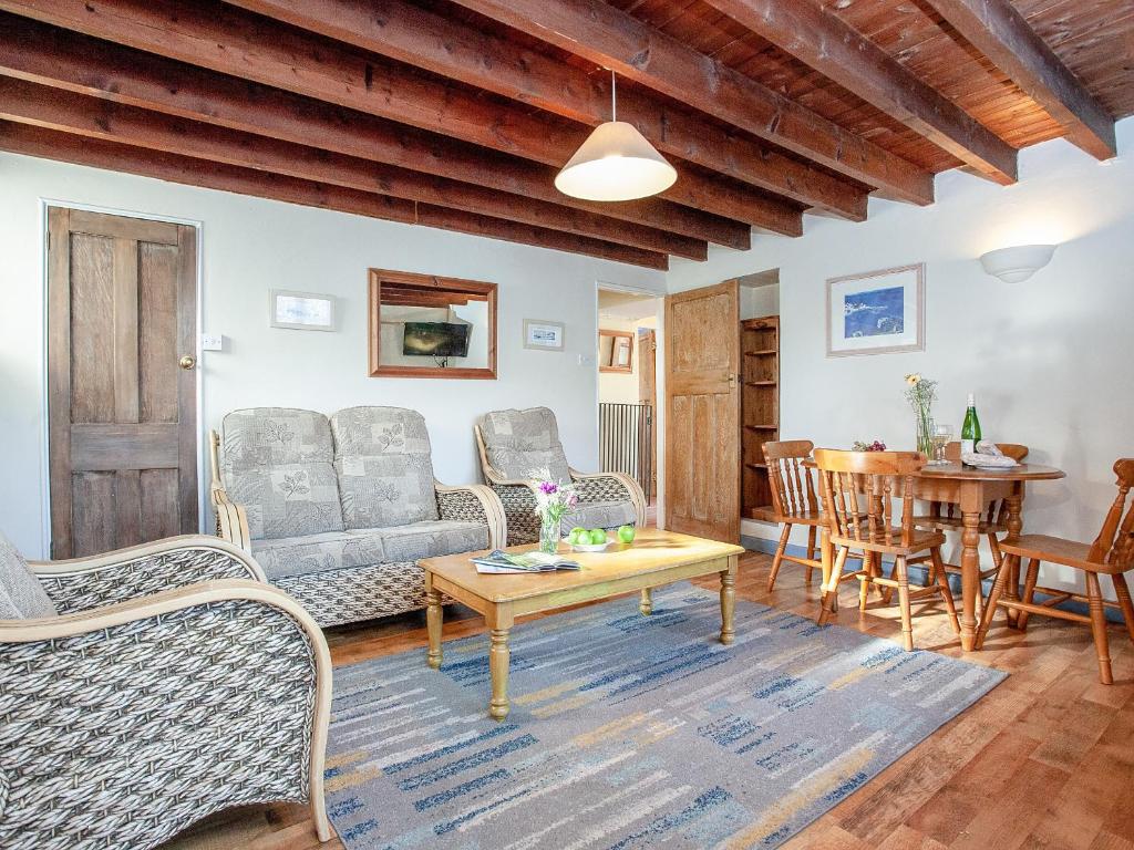 a living room with a couch and chairs and a table at Bowjy Cottage in Cubert