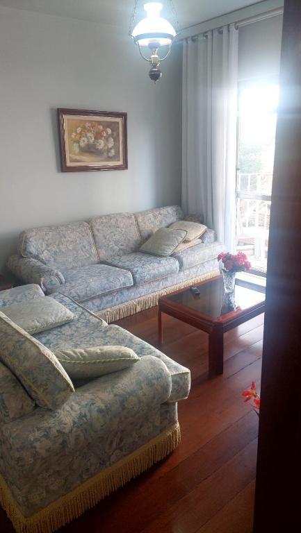 a living room with a couch and a table at Espaço ALA Minas in São Lourenço
