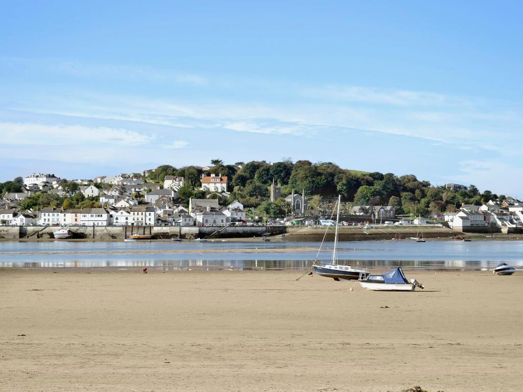 a boat sitting on the sand on a beach at Midships in Instow