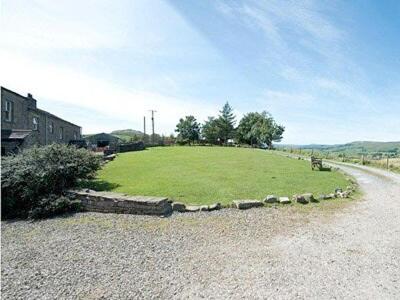 a large field of grass next to a road at 3 Gill Edge Cottages in Countersett