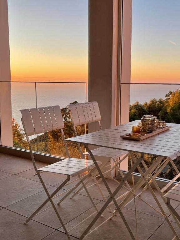 - une salle à manger avec une table et deux chaises dans l'établissement Appartement de luxe Eze village vue mer avec piscine, à Èze