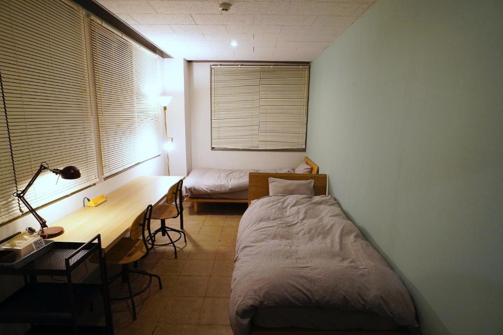 um quarto com uma cama e uma secretária. em La Union Twin room with share bath room - Vacation STAY 31448v em Fukushima