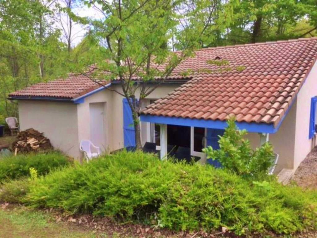 una casa blu e bianca con tetto rosso di Vakantie Woning Le Chat Maison 175 a Écuras
