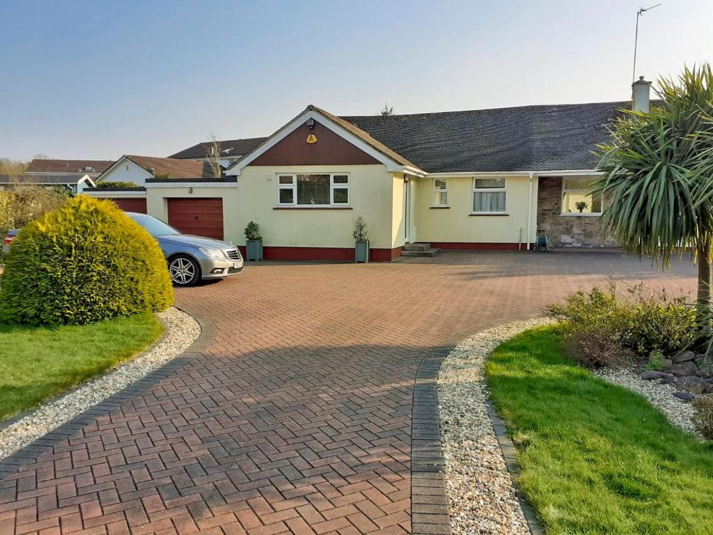 a house with a car parked on a brick driveway at Green View in Churston Ferrers