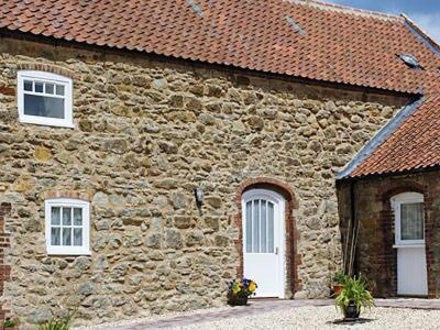 a stone building with two windows and a white door at The Hay Barn- 26724 in North Willingham