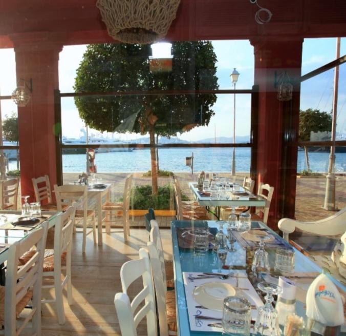 a restaurant with tables and chairs and a view of the water at Aphrodite Studio near Athens Floisvos Marina in Athens