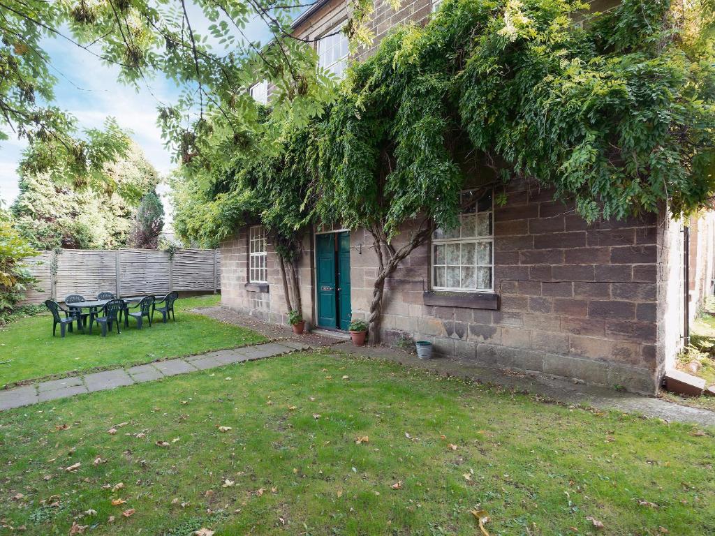 a brick house with a green door and a yard at Clusters Chapel in Belper