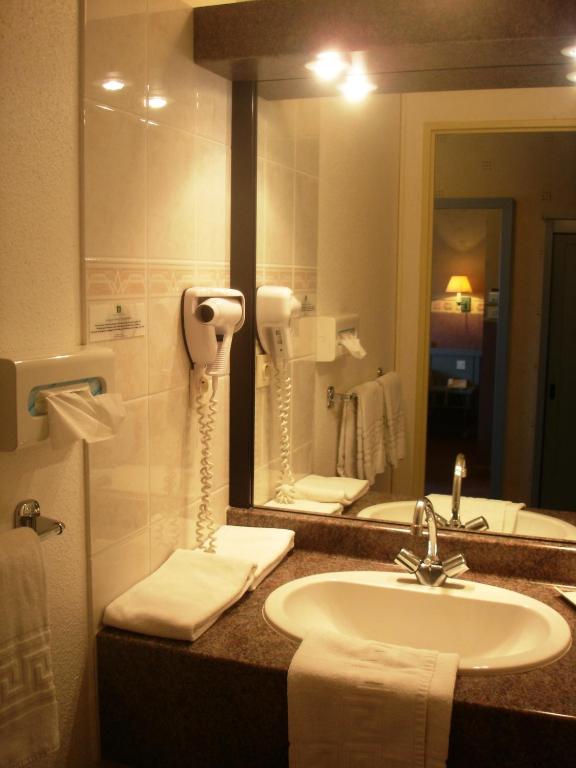 a bathroom with a sink and a mirror at Hotel Restaurant Le Coquelicot in Burnhaupt-le-Haut