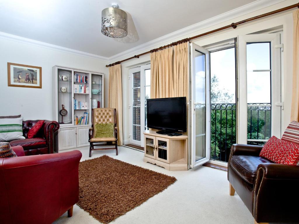 een woonkamer met een tv en een bank bij Cormorant View in Weymouth