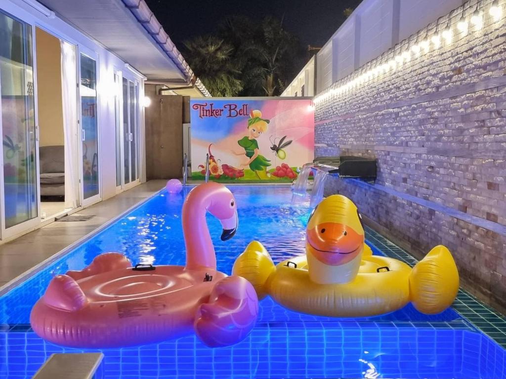 a pool with two toys in a swimming pool at Tinker Bell Pool Villa in Jomtien Beach