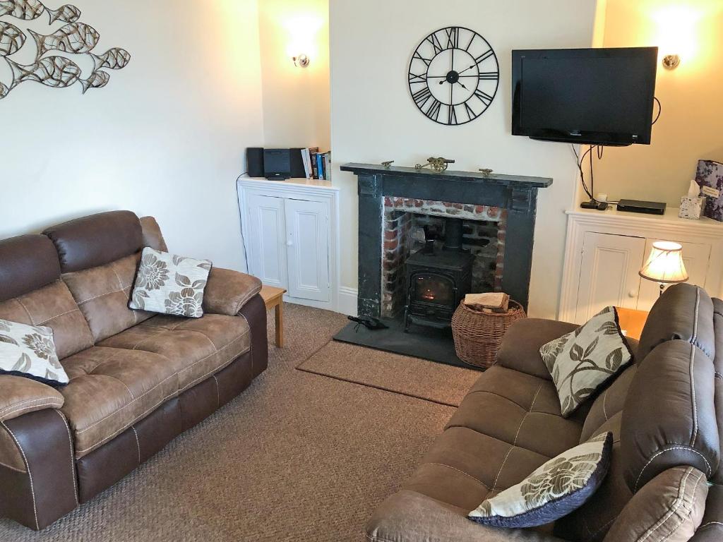 a living room with two couches and a fireplace at Harbour Watch in Charlestown