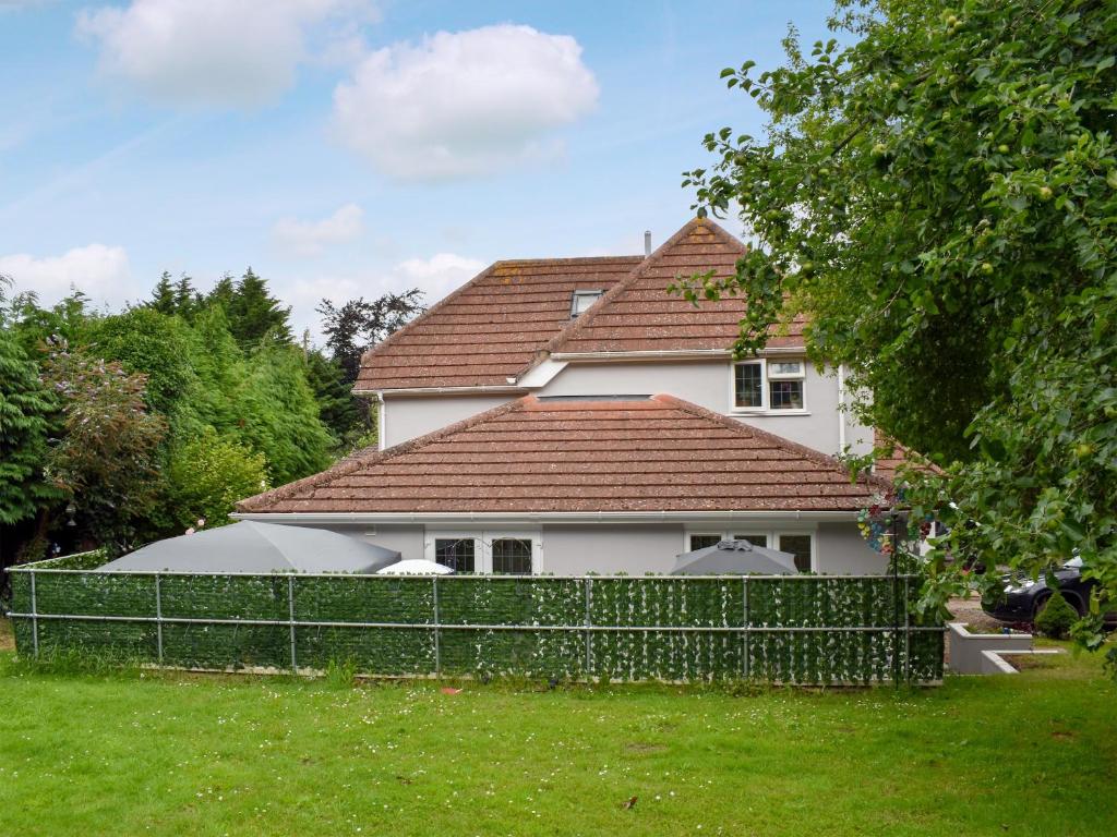 a white house with a fence in front of it at Rose Corner in Countess Wear