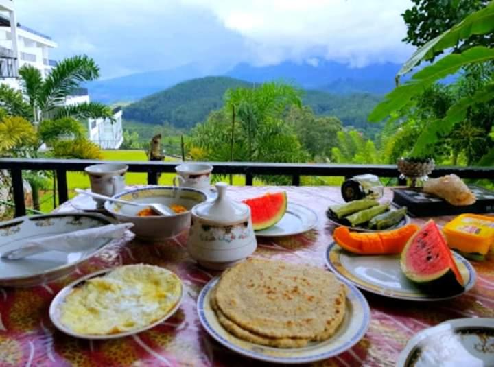 a table with plates of food and fruit on it at Broad view in Ella