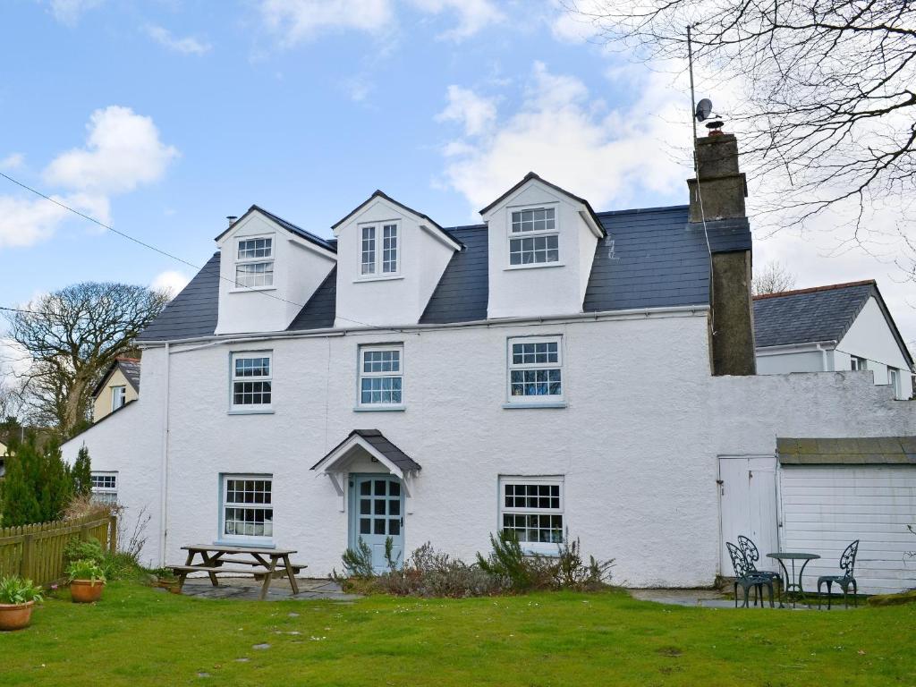 a large white house with a picnic table in front of it at Gumburnville in Lanteglos