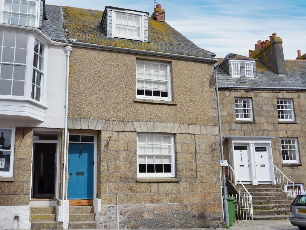 an old house with a blue door and windows at 33 Chapel Street in Penzance