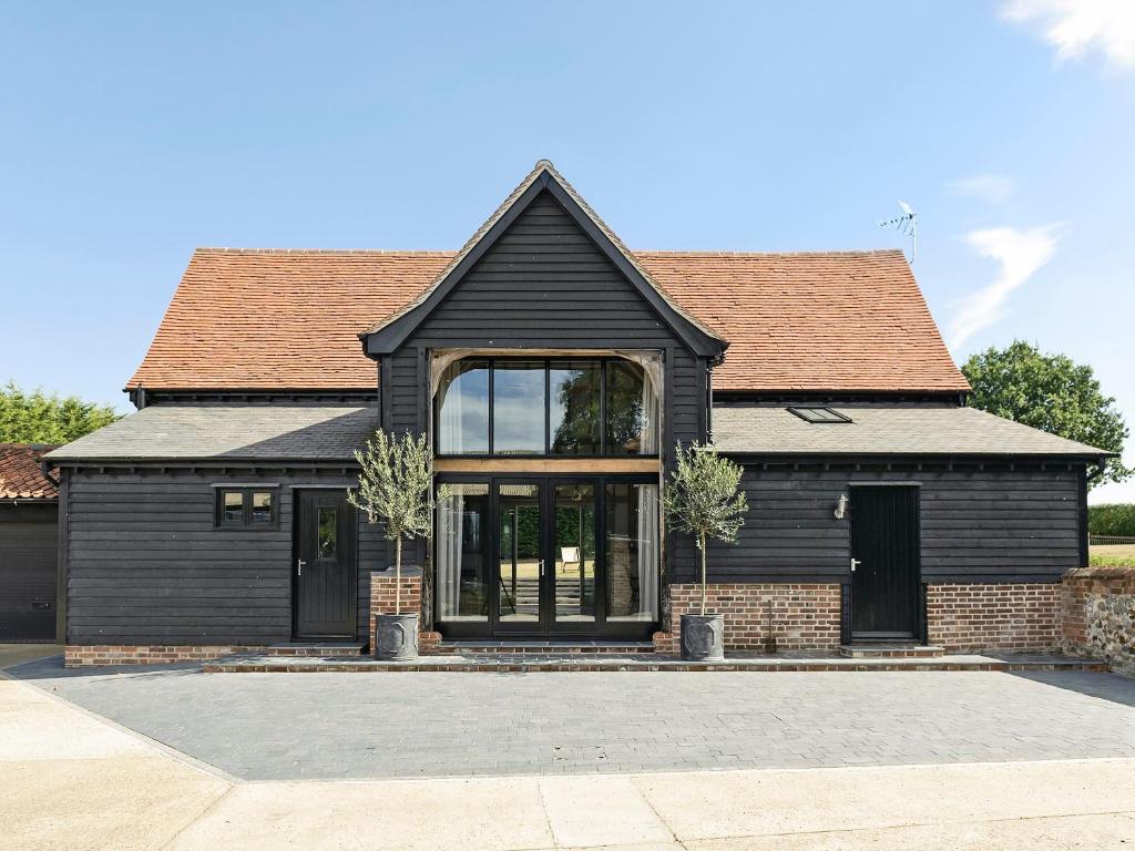 een zwart huis met een zwart dak en ramen bij Tatters Barn in Bradwell