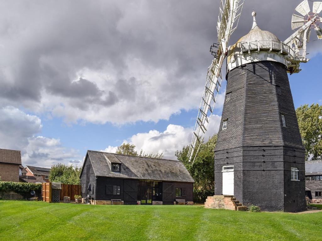 um grande moinho de vento em frente a uma casa em Millers Rest em Willingham