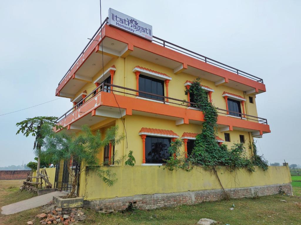 ein gelbes und orangefarbenes Haus mit einem Schild drauf in der Unterkunft Tathāgata Homestay in Rummindei