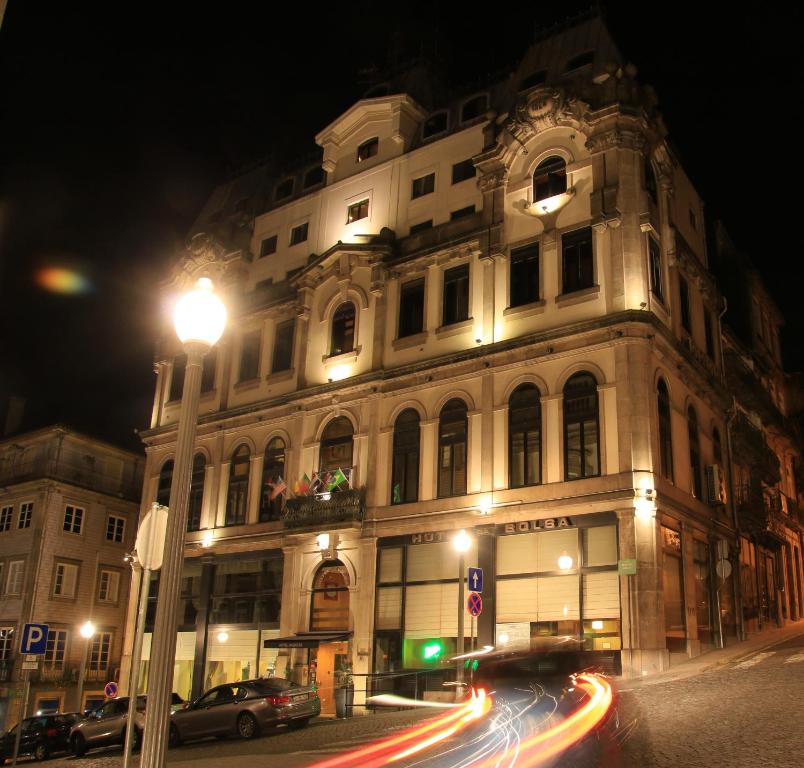 een gebouw met een straatlicht er 's nachts voor bij Hotel da Bolsa in Porto