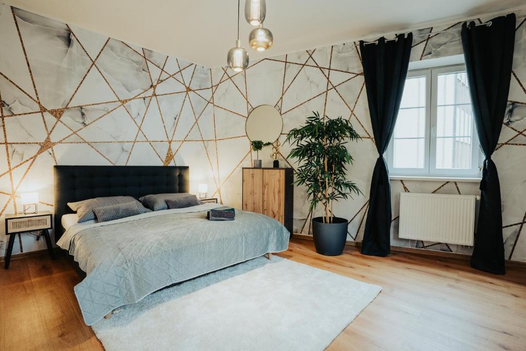 ein Schlafzimmer mit einem Bett und einer geometrischen Wand in der Unterkunft Apartmány J&J in Šumperk