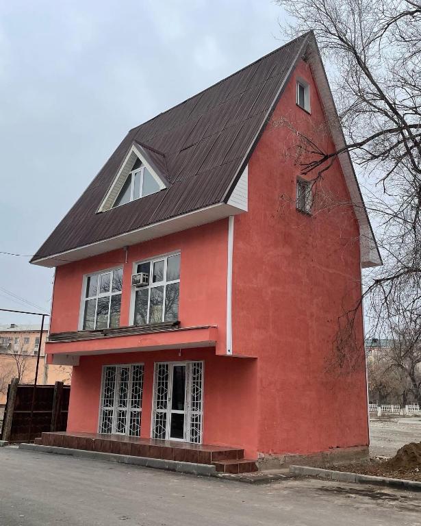a red building with a black roof at ECOPANA in Türkistan