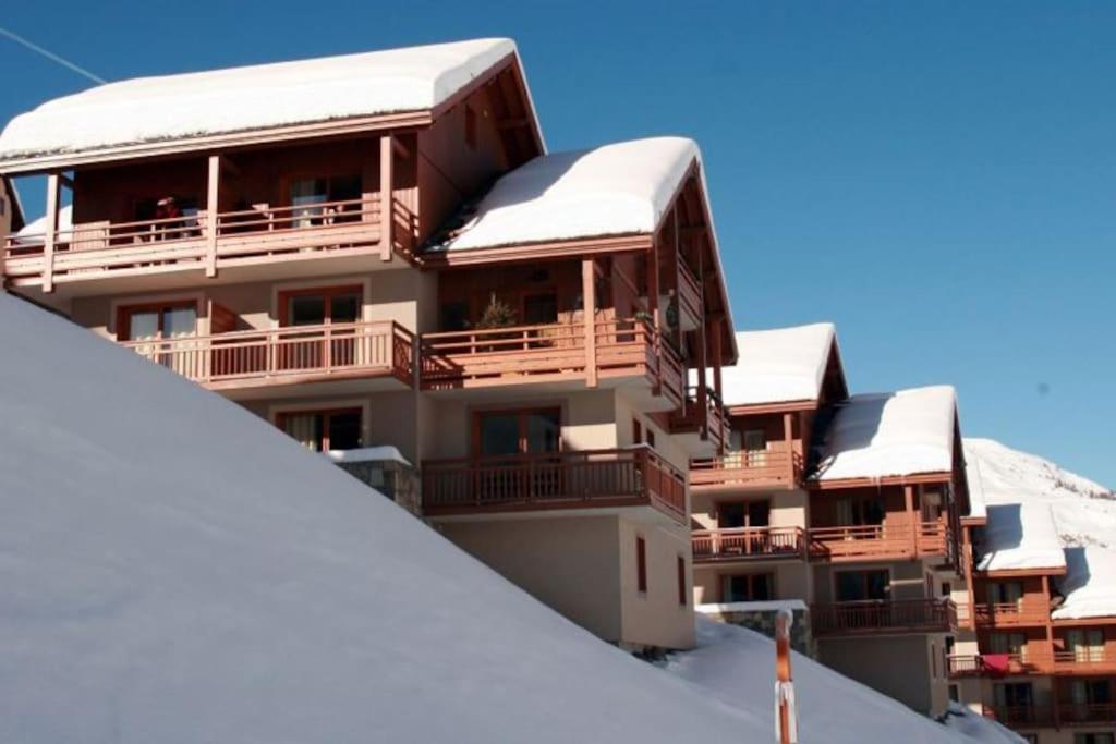 a building with snow covered balconies on top of it at Le hameau des Rennes in Vars