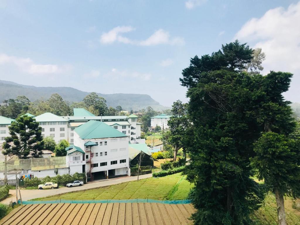 vistas a una ciudad con edificios y un parque en City Apartment’s Nuwara Eliya en Nuwara Eliya